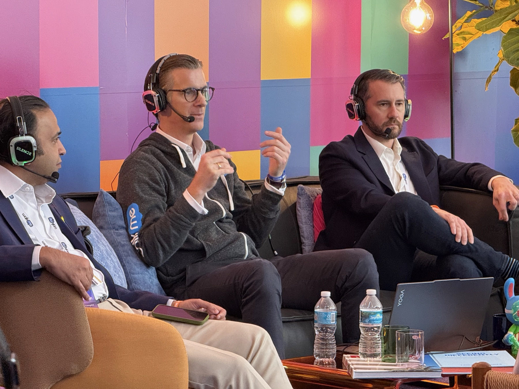 Panelists wearing wireless headset microphones and color-coded headphones