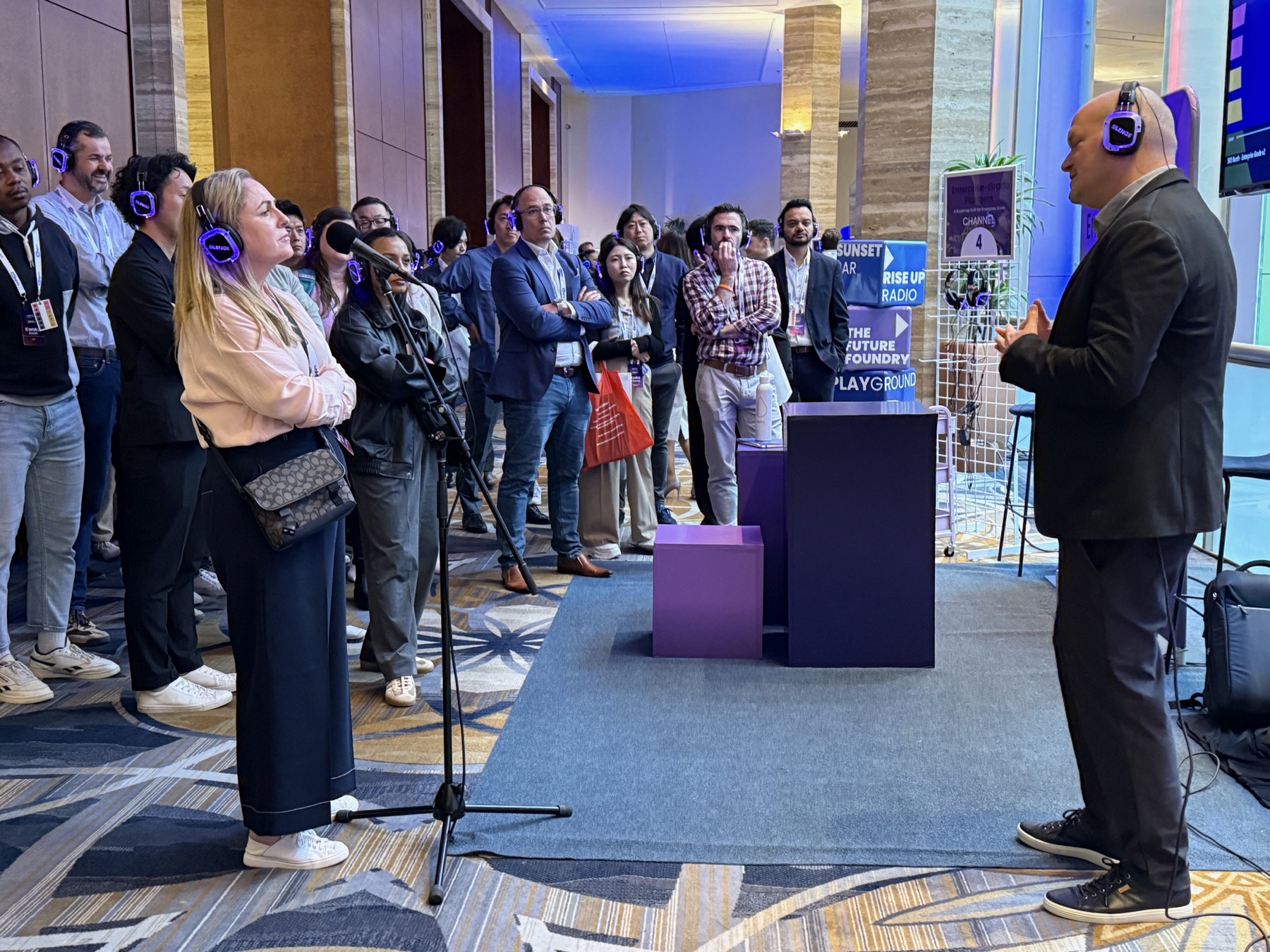 Presenter and audience using matching purple headphones at one silent conference station