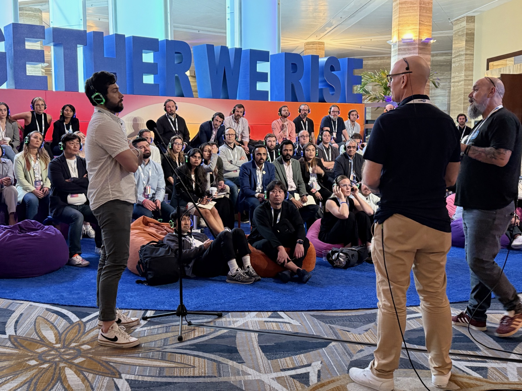 A silent conference audience listening while an attendee asks a question