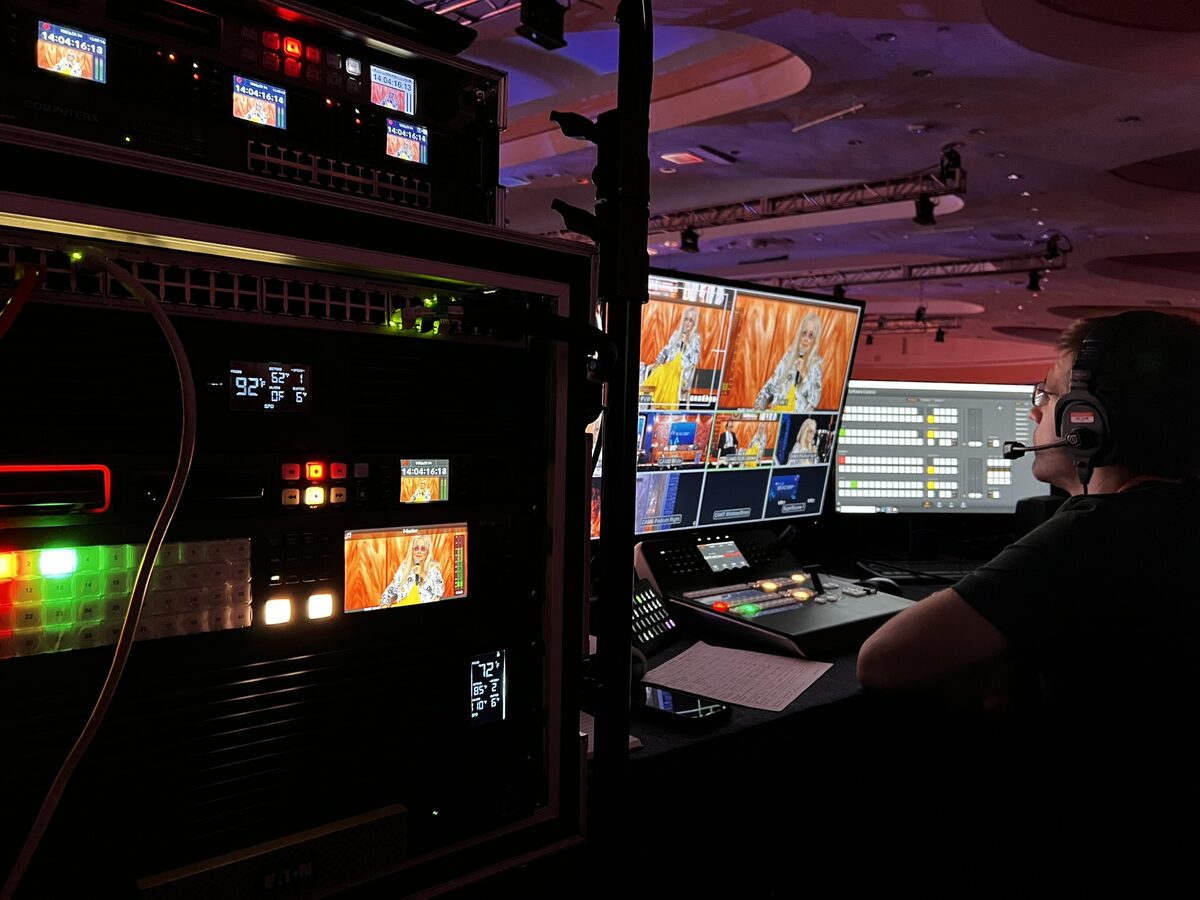 Video engineer at rack with production monitors